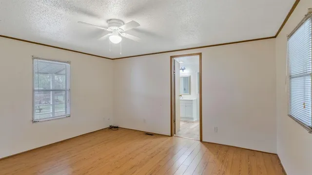 an empty room with windows and fan