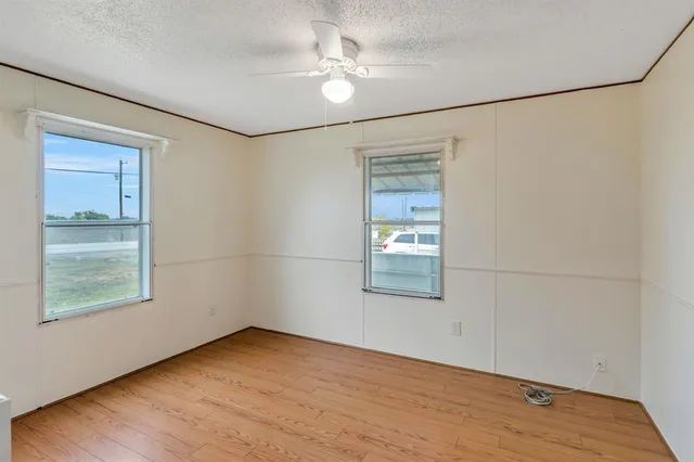 an empty room with a window and a ceiling fan
