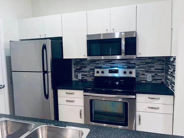 a kitchen with stainless steel appliances a stove a microwave and a refrigerator