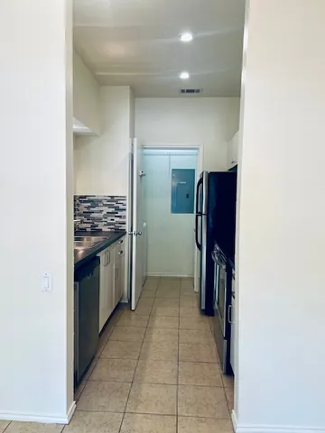 a view of kitchen with refrigerator and cabinets