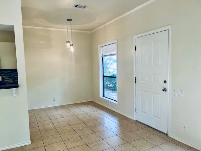 a view of an empty room with window and chandelier fan