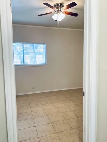 an empty room with cabinet and a chandelier fan