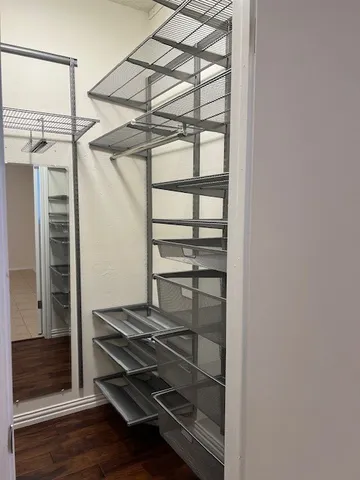 a view of a room with wooden floor and door