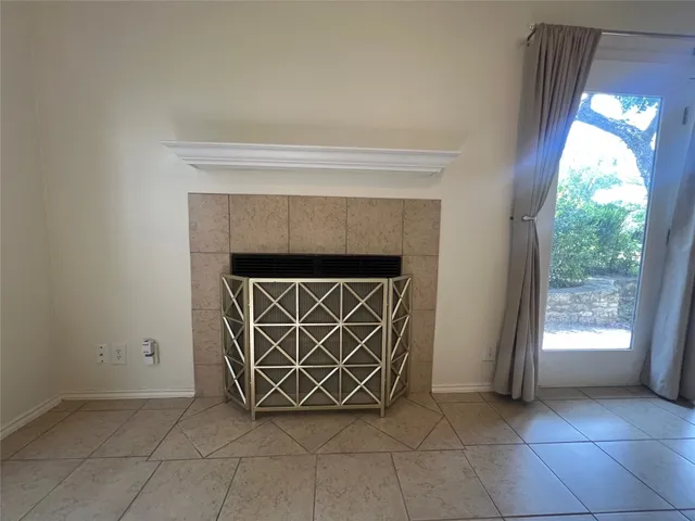 a close view of empty room with wooden floor and a fireplace