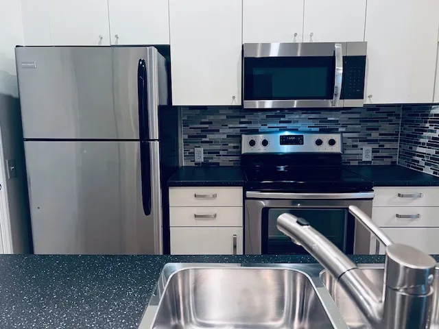 a kitchen with stainless steel appliances a refrigerator a stove a microwave and cabinets