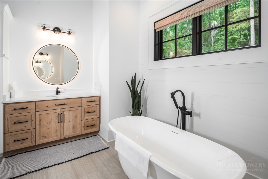1236 Ninebark Road Boone, NC 28607 - Photo 21 of 50 a bathroom with a granite countertop sink a mirror and a window