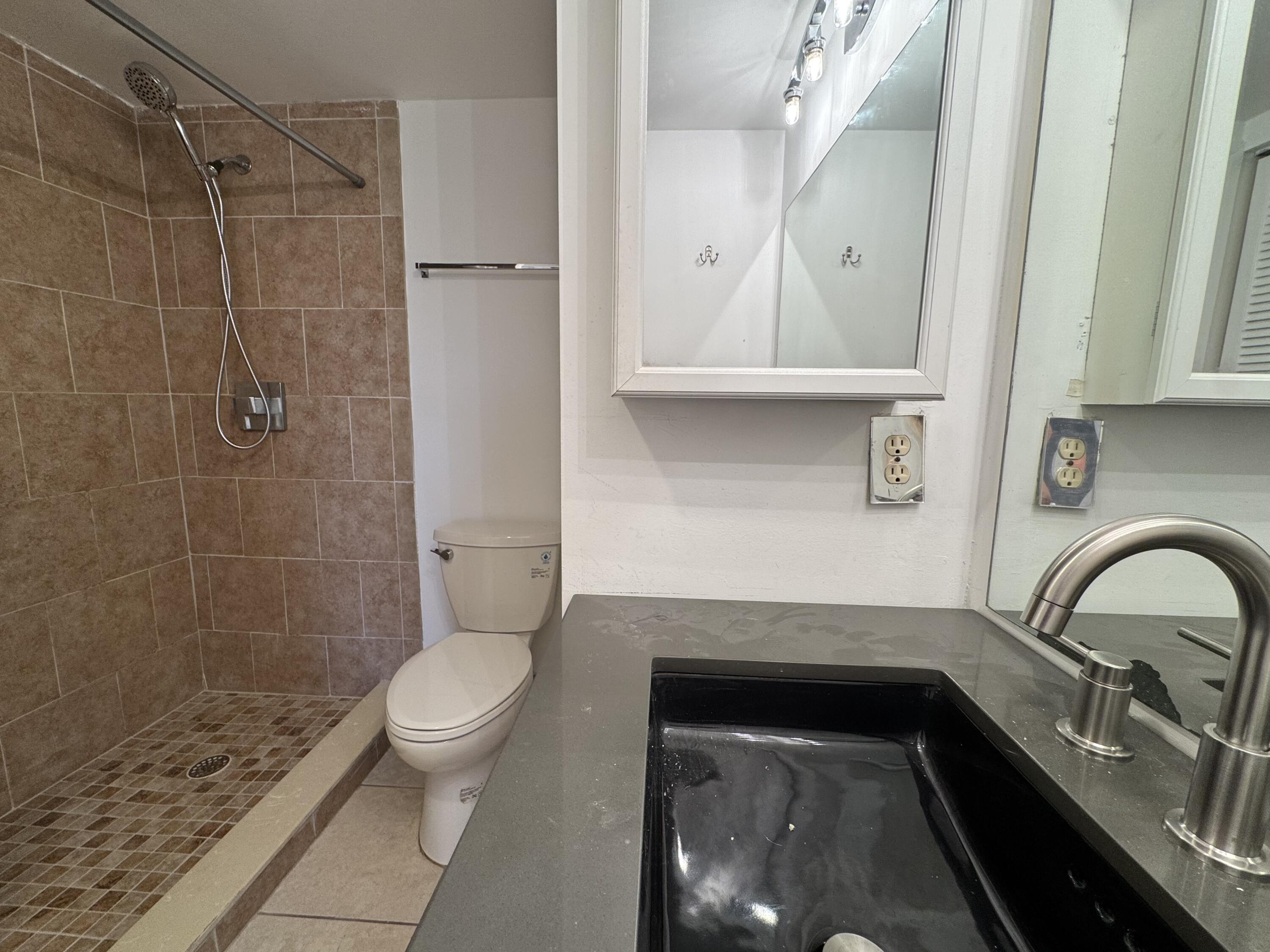 4019 Lincoln A Boca Raton, FL 33434 - Photo 13 of 36 a bathroom with a sink a toilet and a shower