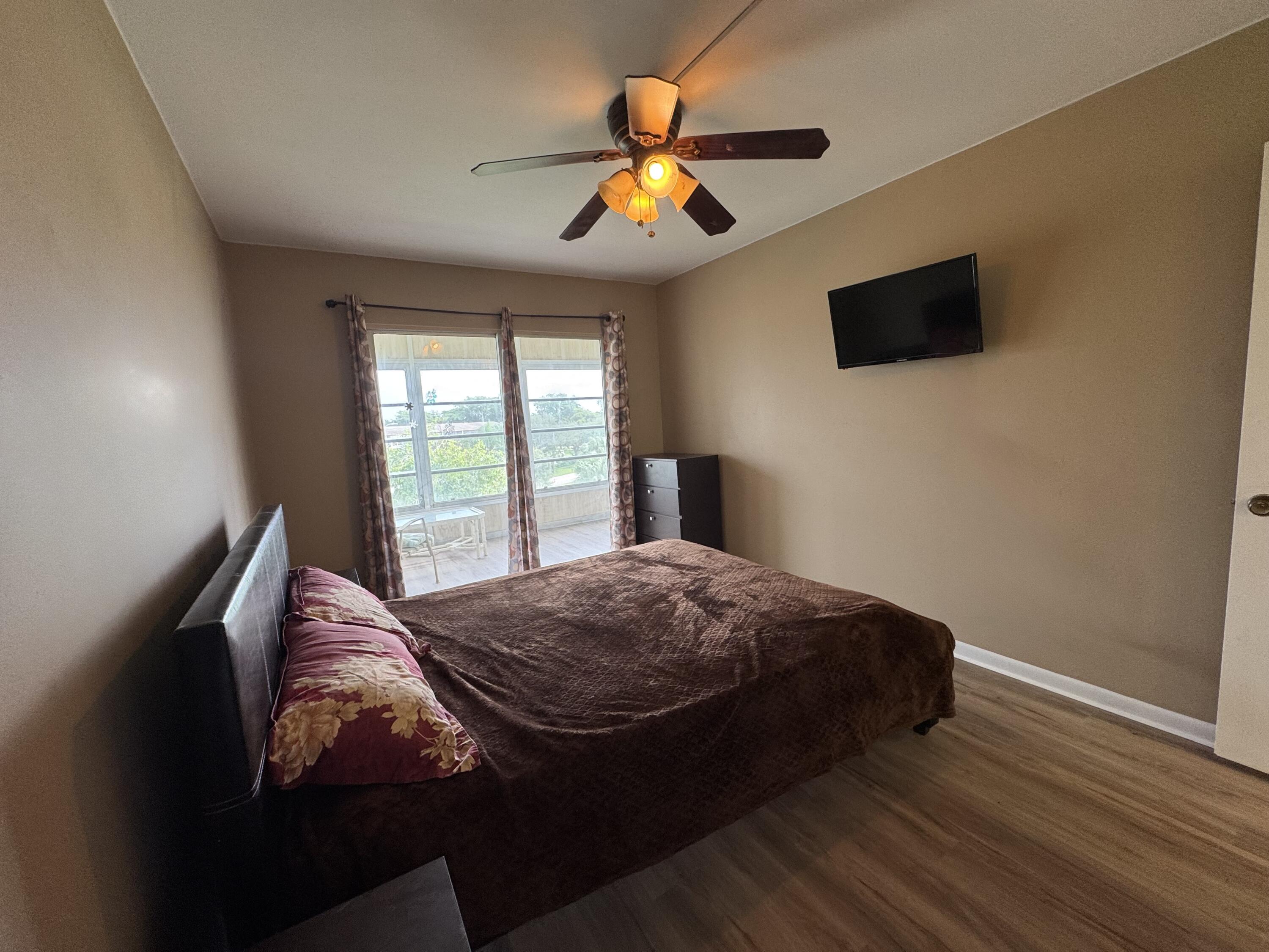 4019 Lincoln A Boca Raton, FL 33434 - Photo 22 of 36 a bedroom with a bed and a flat screen tv