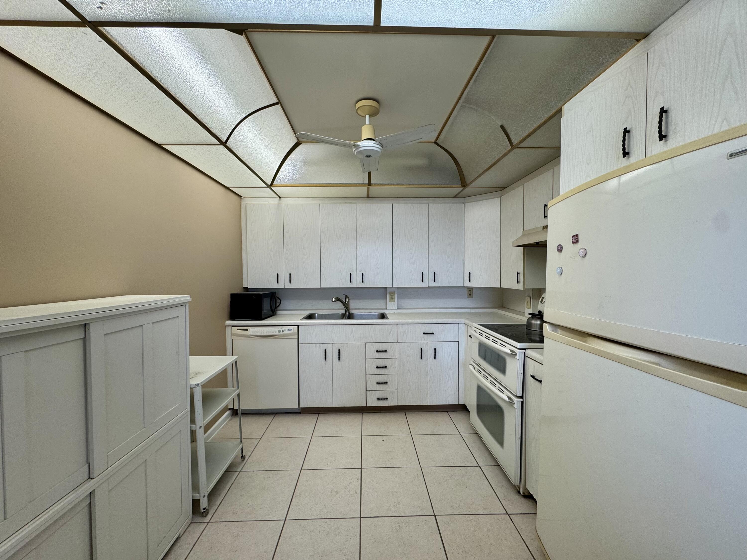 4019 Lincoln A Boca Raton, FL 33434 - Photo 8 of 36 a kitchen with a sink a stove top oven and cabinets