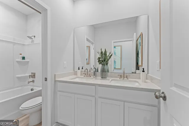 a bathroom with a granite countertop toilet a sink and a bathtub