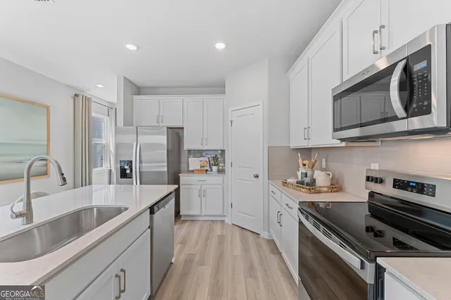 a kitchen with stainless steel appliances a stove sink microwave and cabinets