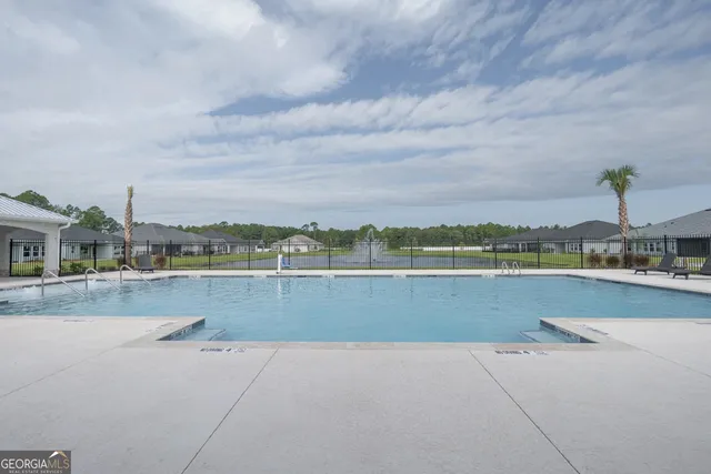 a view of a hallway with wooden floor and a bathroom