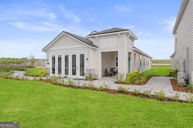 a view of a house with a yard and pathway