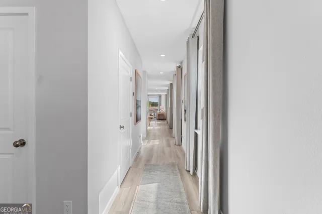 a view of a hallway with a white walls and stairs
