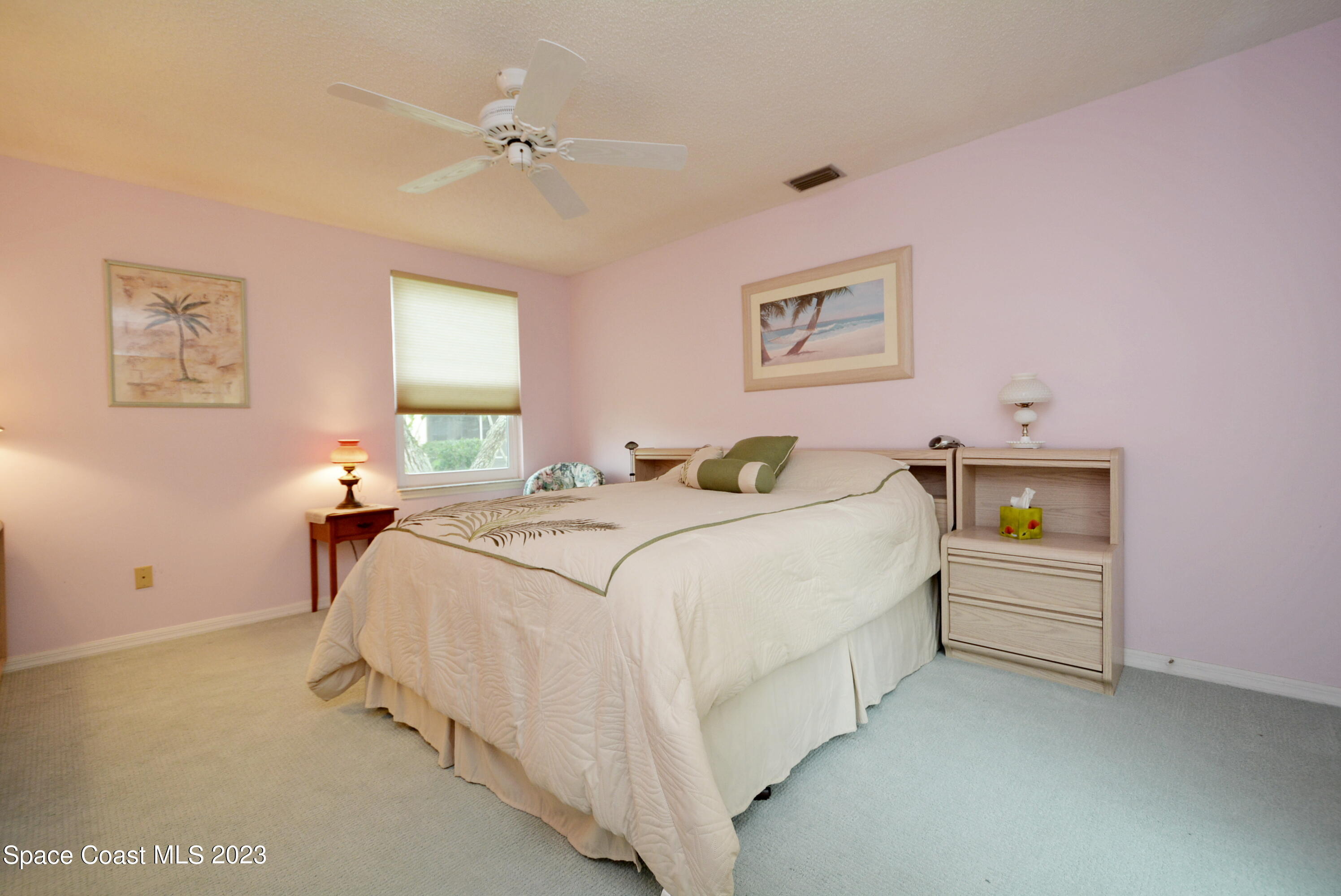 738 Green Valley Lane Melbourne, FL 32940 - Photo 20 of 40 a bedroom with a bed and a chandelier