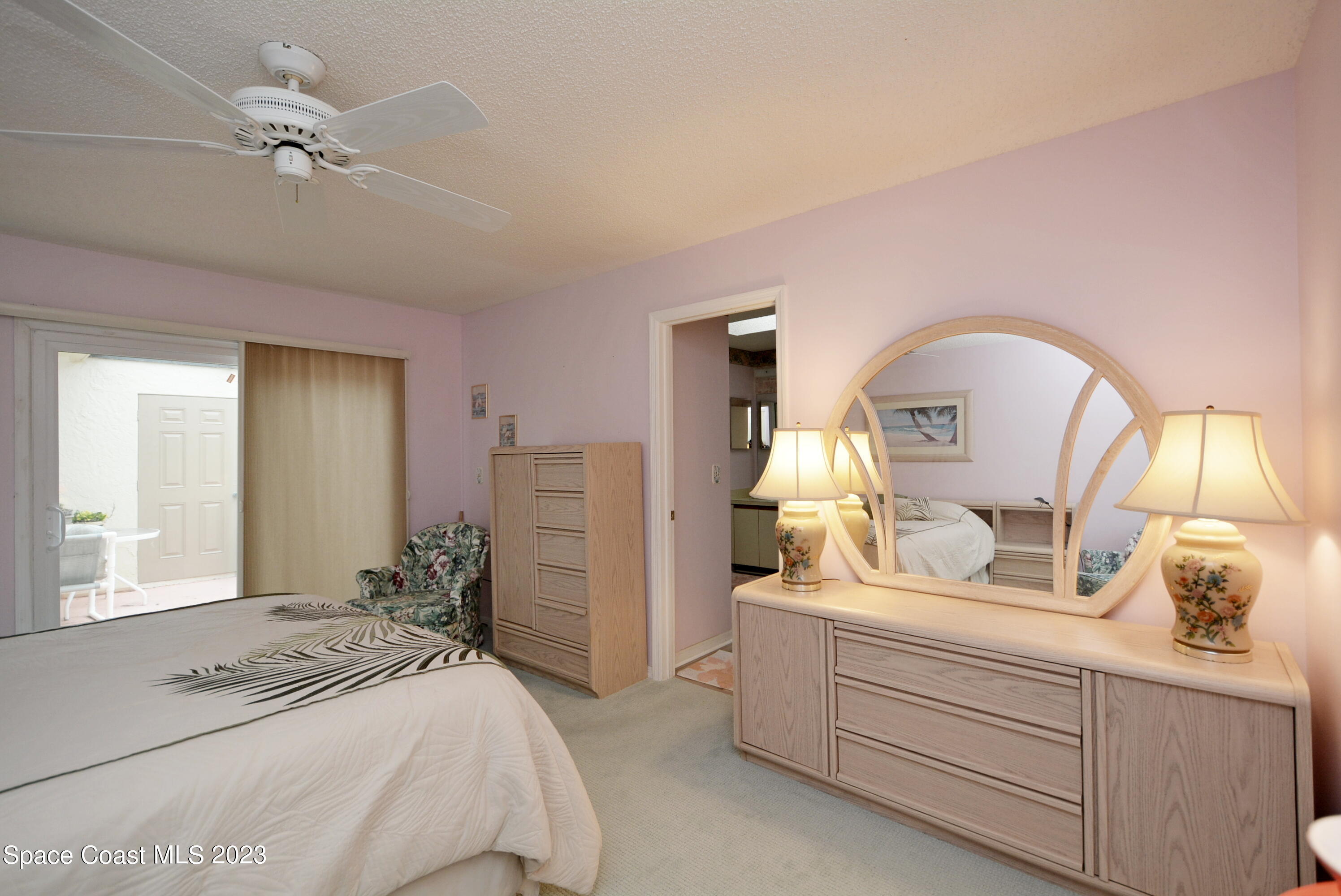 738 Green Valley Lane Melbourne, FL 32940 - Photo 21 of 40 a bedroom with a bed and a chandelier