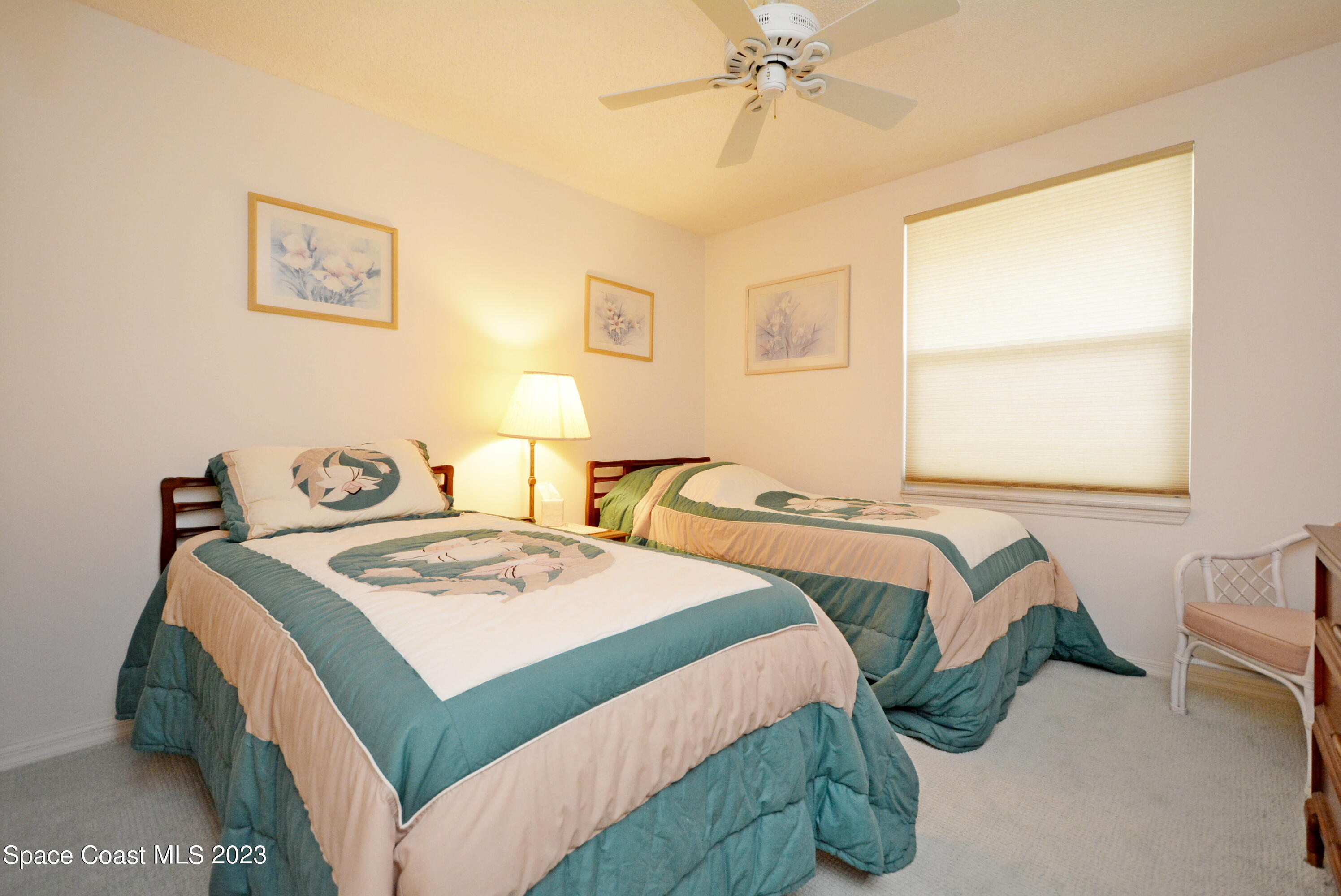 738 Green Valley Lane Melbourne, FL 32940 - Photo 28 of 40 a bedroom with a bed and a chandelier