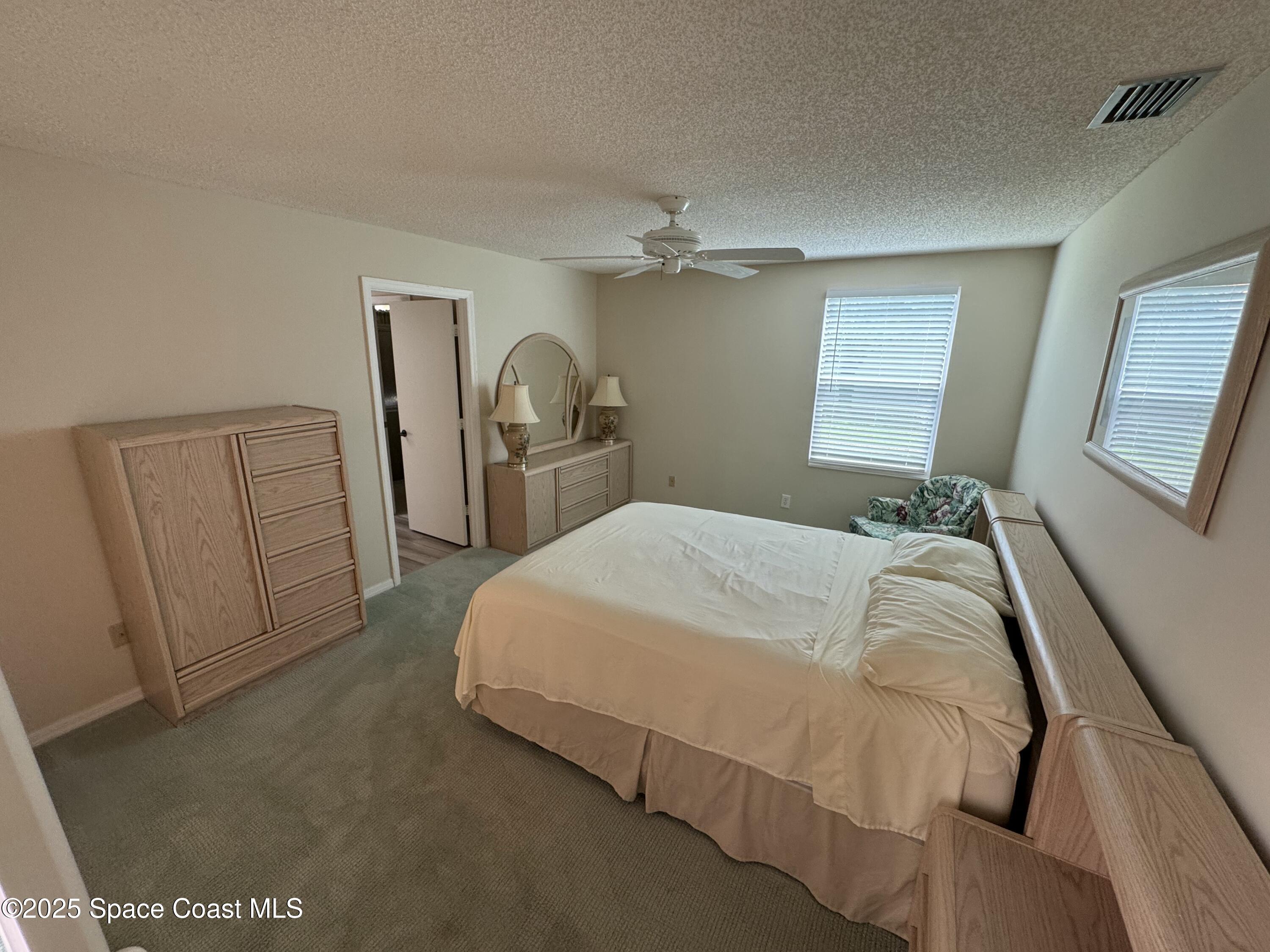 738 Green Valley Lane Melbourne, FL 32940 - Photo 40 of 40 a bedroom with a bed and a mirror