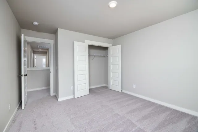 an empty room with closet and a bathroom
