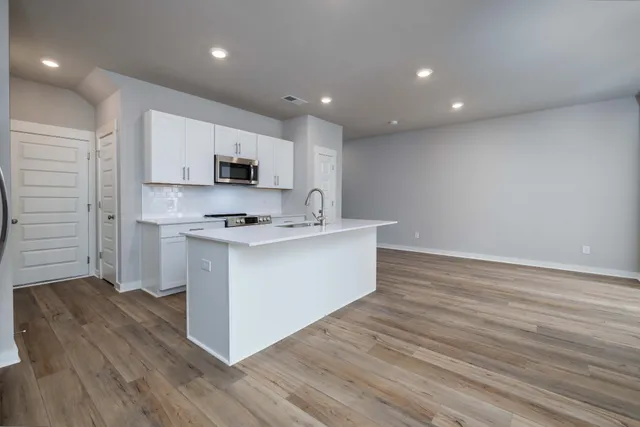 a kitchen with stainless steel appliances granite countertop a stove a sink and a refrigerator