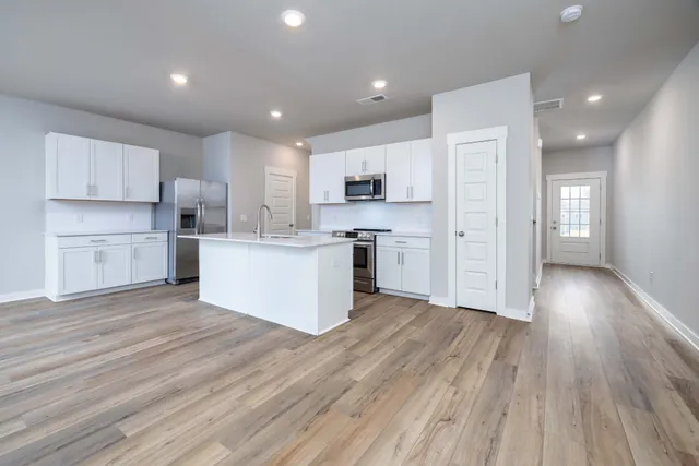 a view of kitchen with wooden floor and electronic appliances