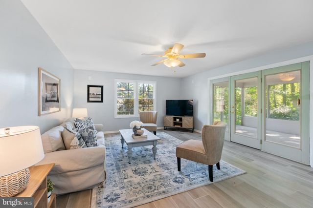 a living room with furniture a flat screen tv and a large window