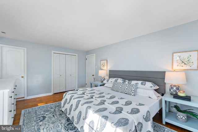 a bedroom with a bed and a lamp on dresser