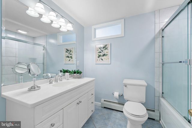 a bathroom with a sink a toilet a mirror and shower