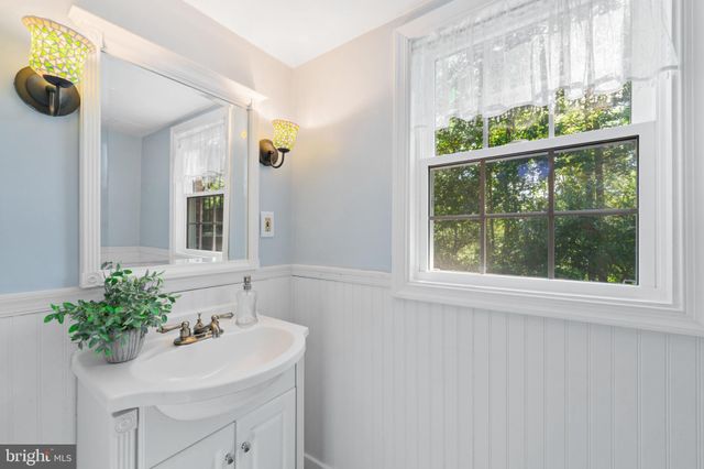 a bathroom with a sink mirror and window