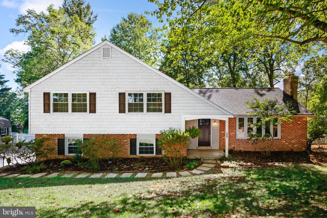 a front view of a house with a yard and green space