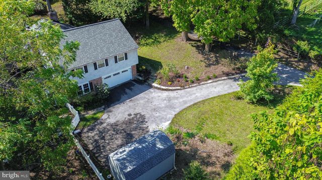 an aerial view of residential house with outdoor space and trees all around