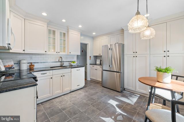 a kitchen with a refrigerator and a stove top oven