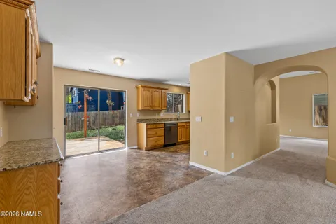 a view of a kitchen with refrigerator and more cabinets