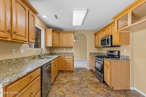 a kitchen with stainless steel appliances granite countertop a sink stove microwave and refrigerator