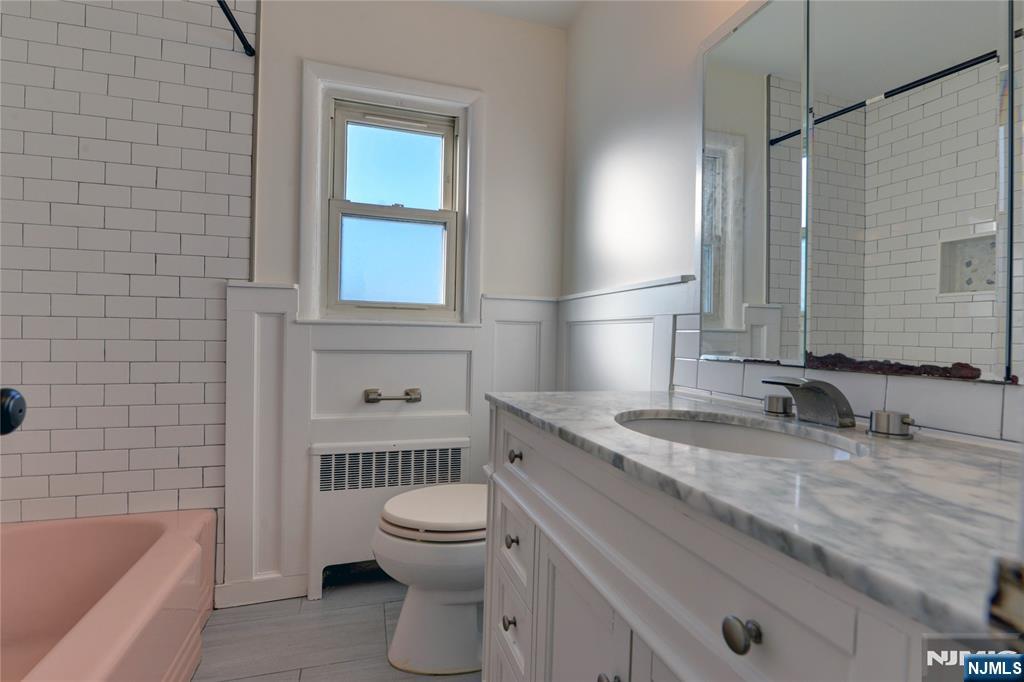 255 Bogert Road, Unit 2A River Edge, NJ 07661 - Photo 9 of 25 a bathroom with a granite countertop toilet a sink and bathtub