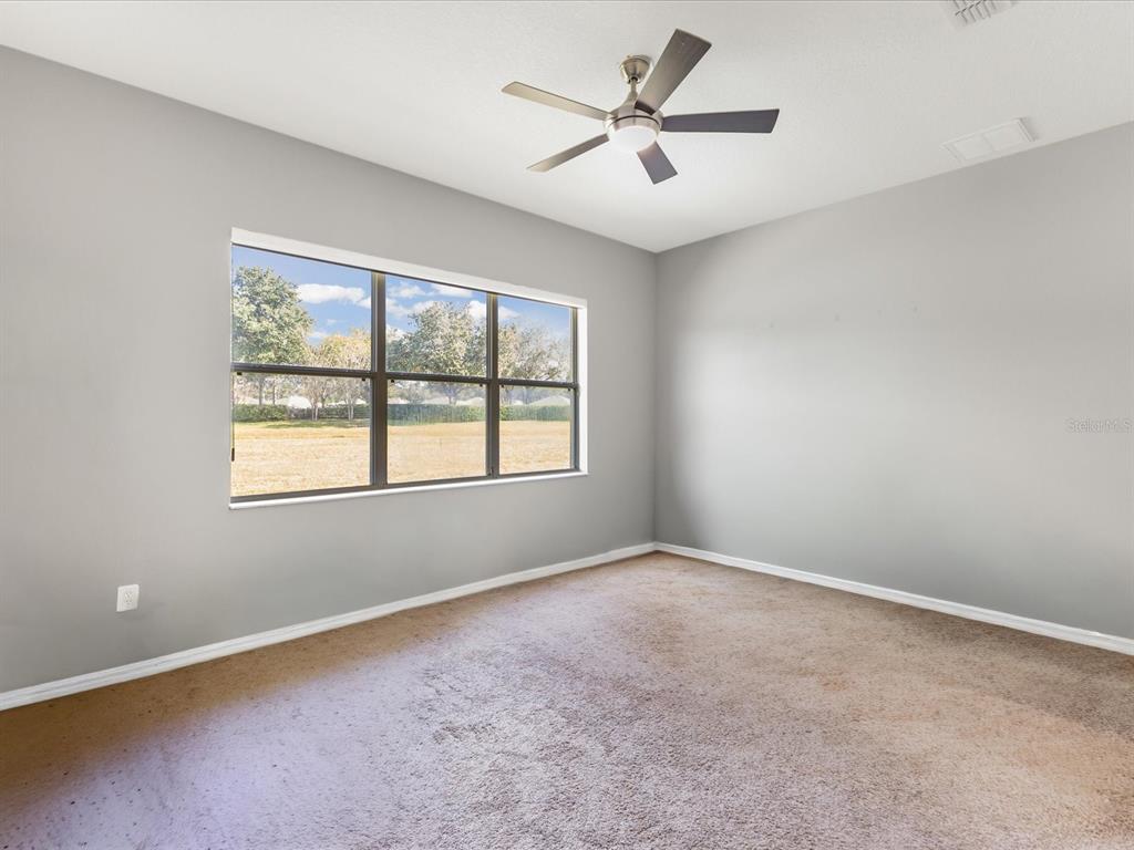 5347 Cappleman Loop Brooksville, FL 34601 - Photo 13 of 28 an empty room with a window and a fan