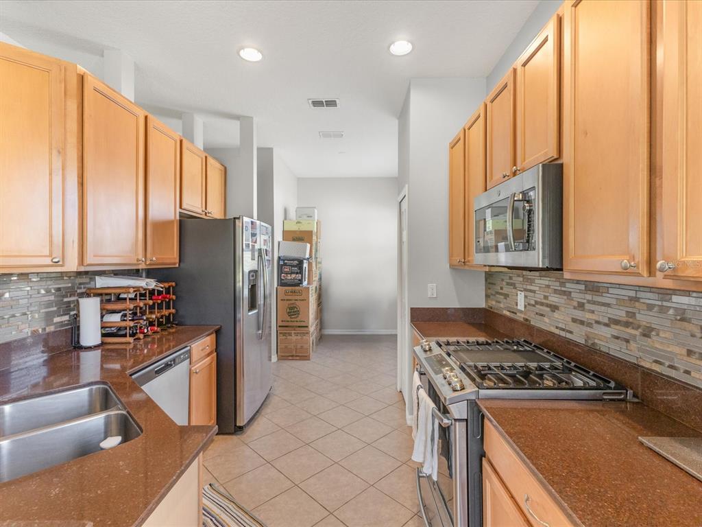 5347 Cappleman Loop Brooksville, FL 34601 - Photo 6 of 28 a kitchen with stainless steel appliances granite countertop a stove a refrigerator and a sink
