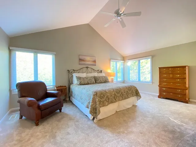 a bedroom with bed and furniture with large window