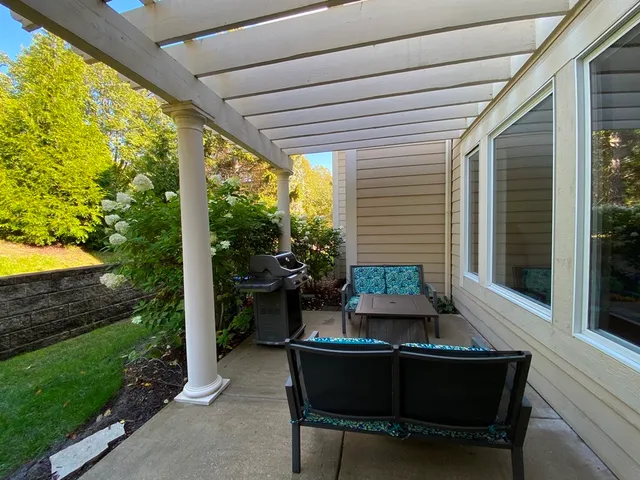a patio with table and chairs and potted plants