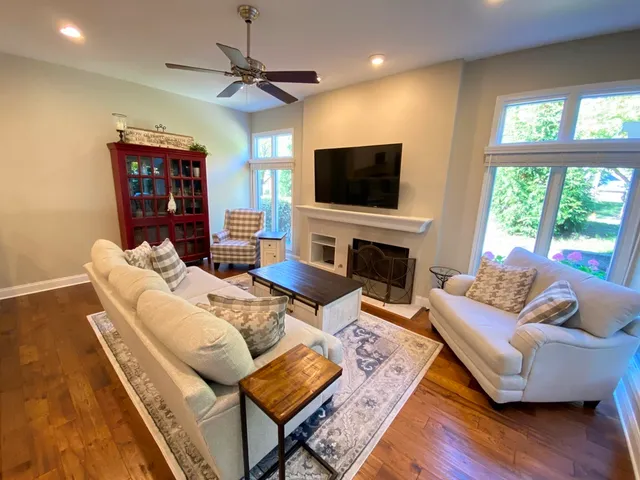 a living room with furniture a flat screen tv and a fireplace