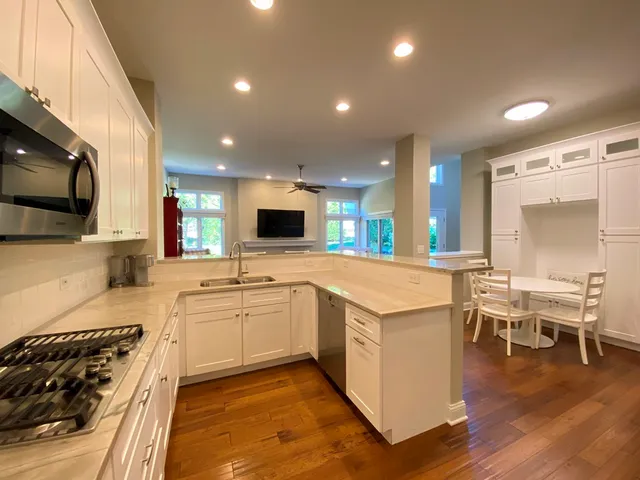 a large kitchen with stainless steel appliances kitchen island granite countertop a stove and a sink