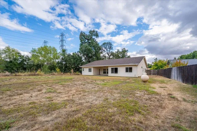 a view of a yard in front of a house with large trees