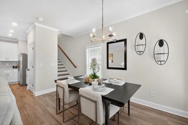 a kitchen with stainless steel appliances kitchen island granite countertop a refrigerator a sink dishwasher and a stove with wooden floor