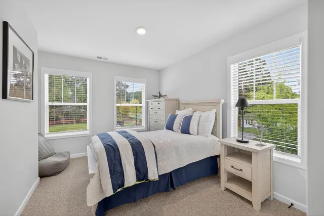 a bedroom with a large bed and a chandelier