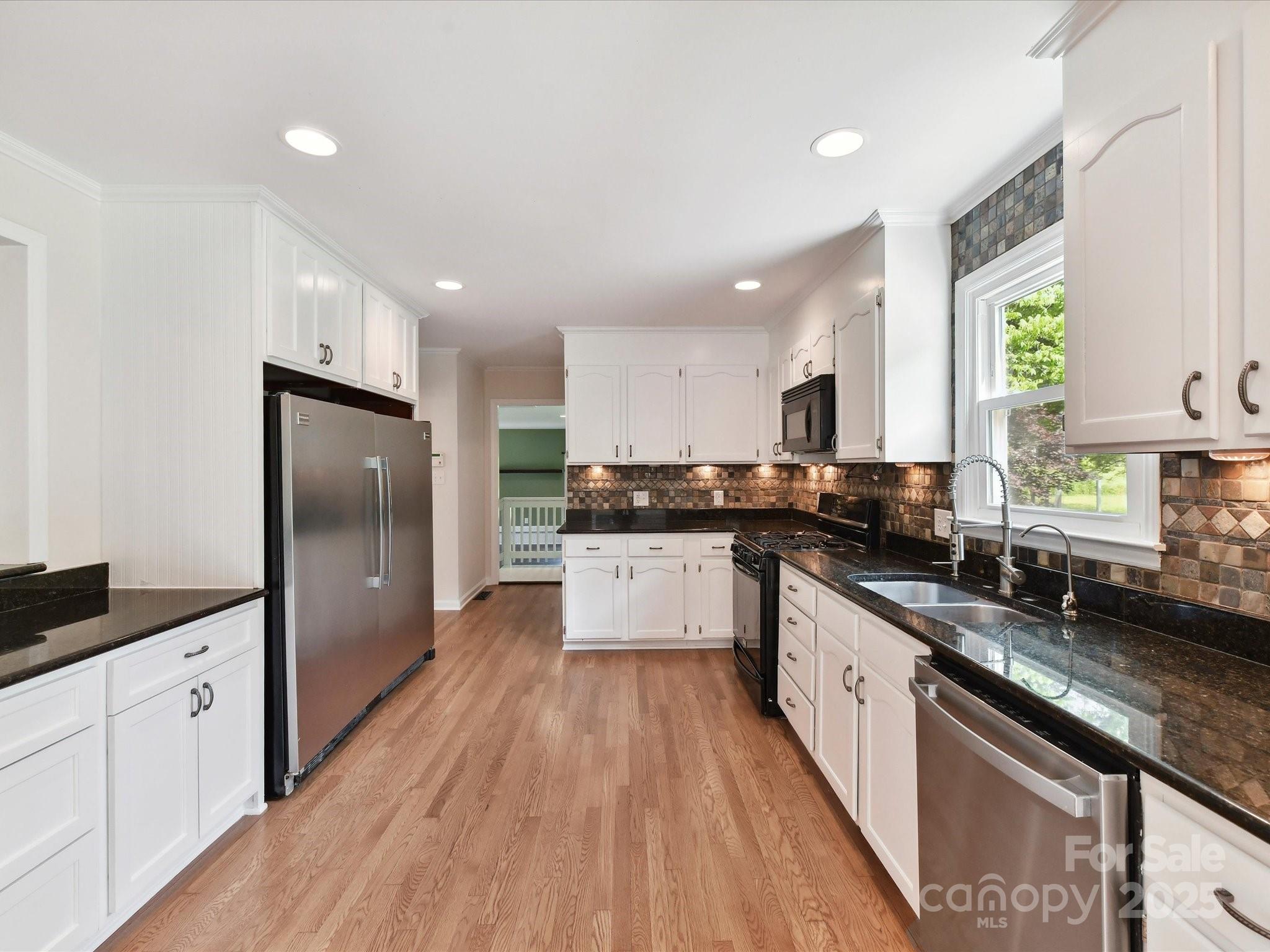 915 Gate Road Monroe, NC 28112 - Photo 16 of 46 a large kitchen with stainless steel appliances kitchen island granite countertop a lot of counter space and wooden floor