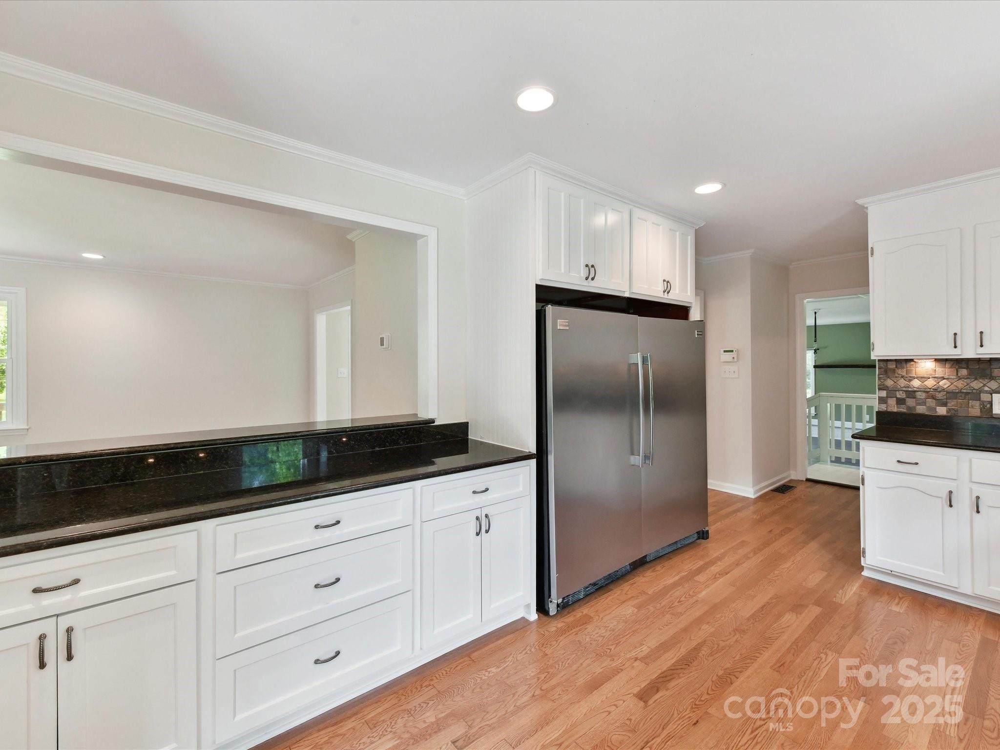 915 Gate Road Monroe, NC 28112 - Photo 18 of 46 a kitchen with granite countertop white cabinets and stainless steel appliances