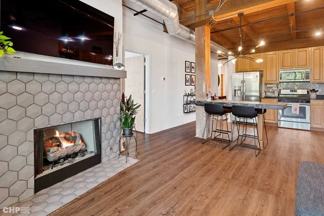 a kitchen with stainless steel appliances a stove a sink dishwasher and a refrigerator with wooden floor