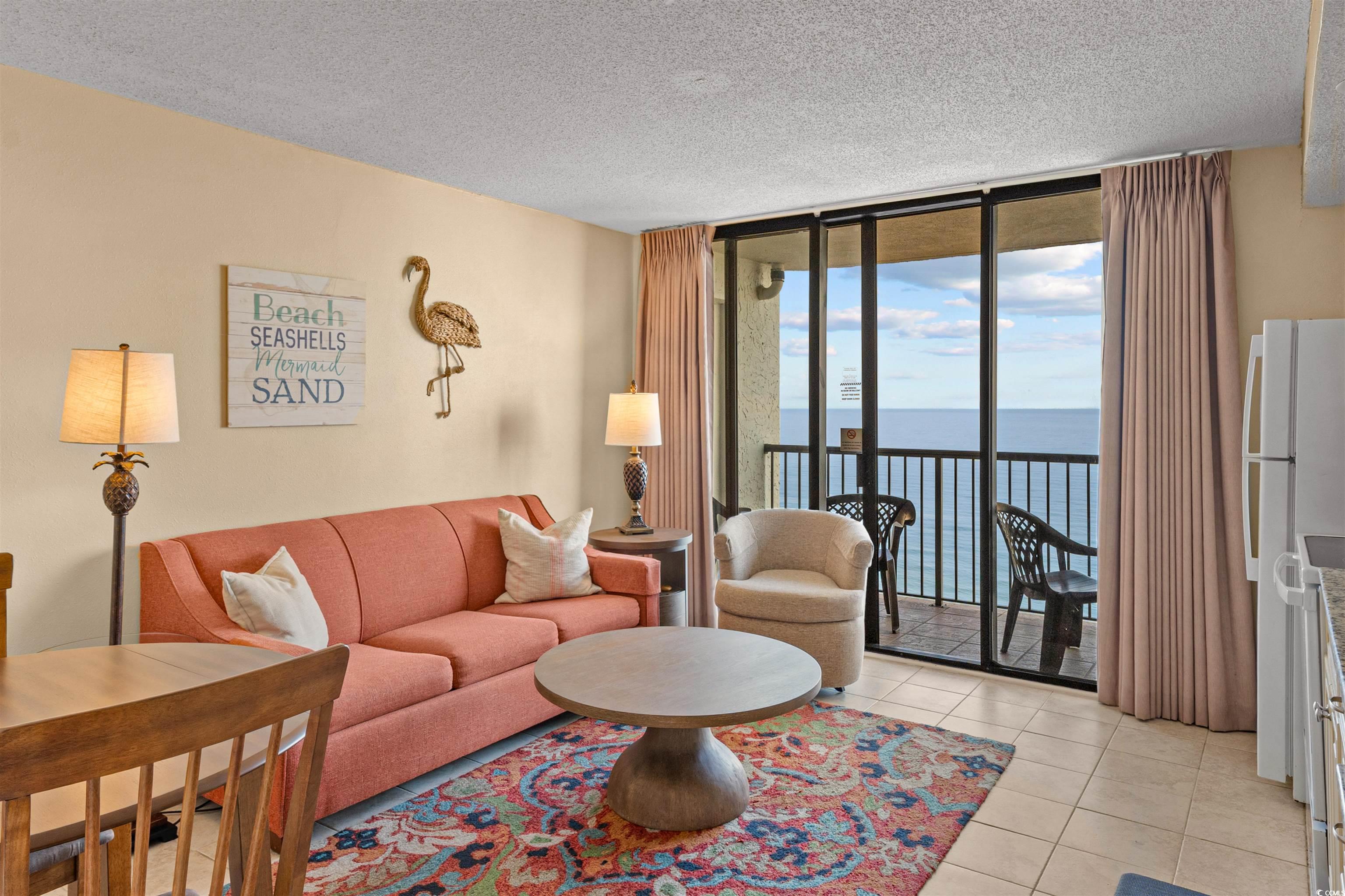 5308 North Ocean Boulevard, Unit 2006 Myrtle Beach, SC 29577 - Photo 4 of 37 Living area with oceanfront view, floor to ceiling glass slider, textured ceiling, and tile floors