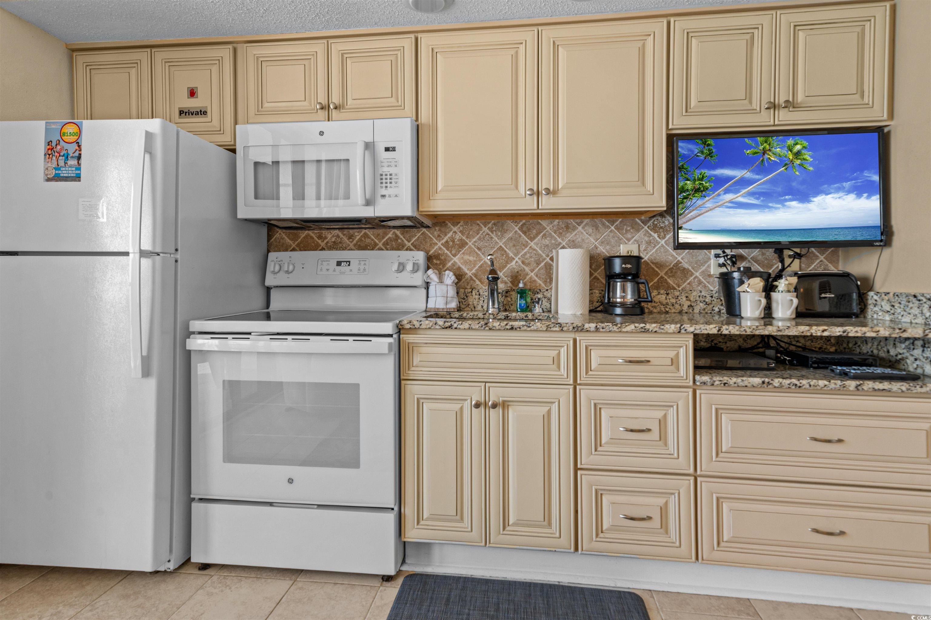 5308 North Ocean Boulevard, Unit 2006 Myrtle Beach, SC 29577 - Photo 5 of 37 Kitchen with cream cabinets, white appliances, and granite countertops