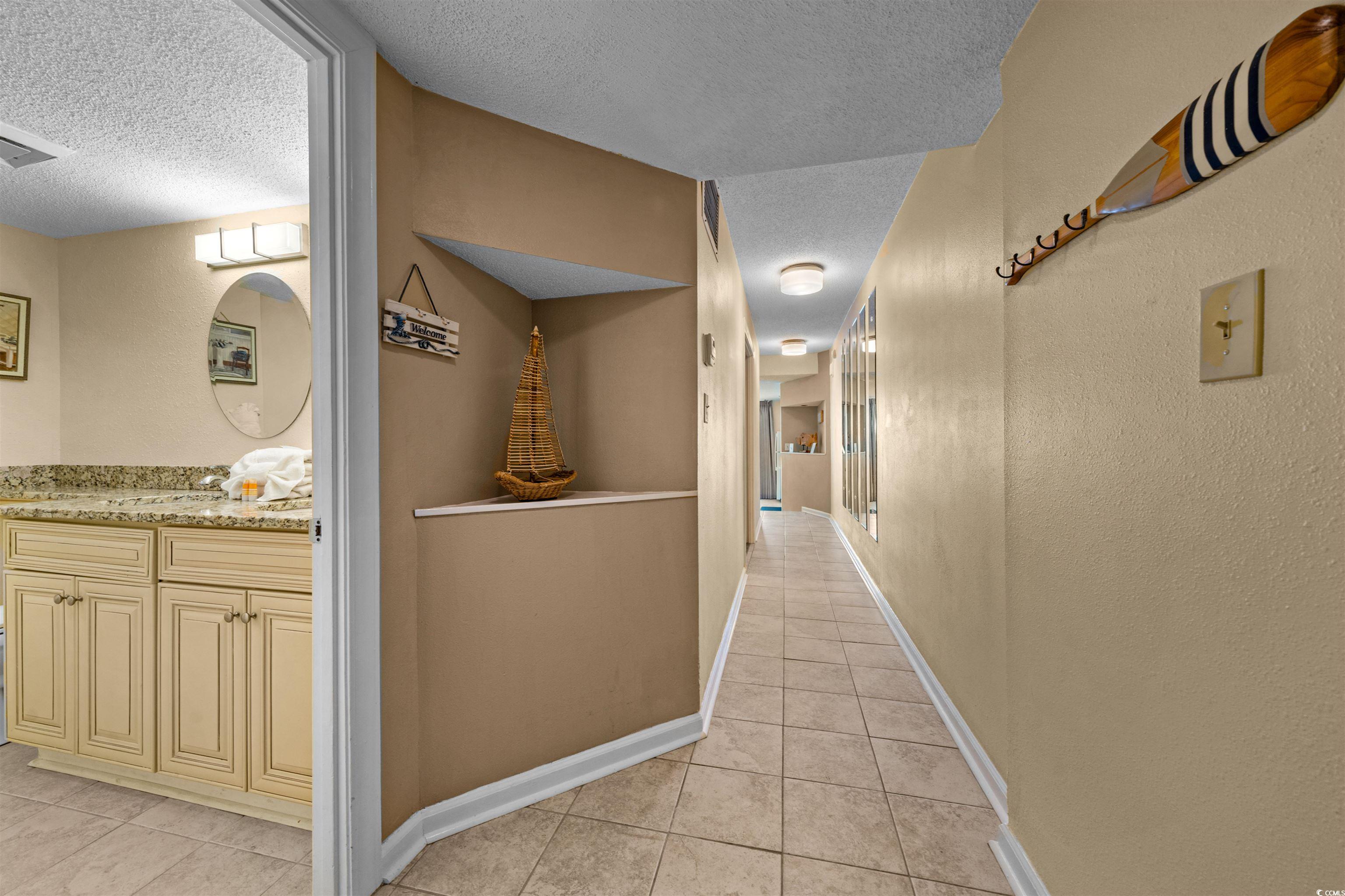 5308 North Ocean Boulevard, Unit 2006 Myrtle Beach, SC 29577 - Photo 7 of 37 Foyer entry to unit featuring an art nook, textured ceiling, light tile patterned floors, and a textured walls.